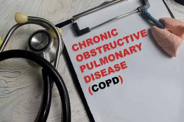 Concept of COPD - Chronic Obstructive Pulmonary Disease write on clipboard isolated on Wooden Table.