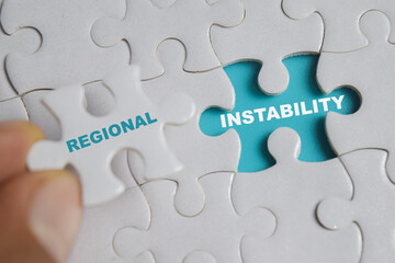 Fototapeta premium Piece of jigsaw puzzle with word regional and instability. Business and finance concept