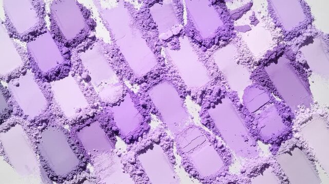 From-above shot of abundant violet shades smeared powder heaps highlighted by orbiting directional light casting shifting shadows