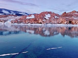 Baikal Lake in winter. Beautiful landscape with mountains reflected in ice of frozen Small Sea