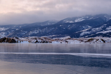 Baikal Lake in winter. Beautiful landscape with mountains reflected in ice of frozen Small Sea
