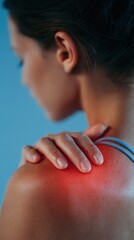 Woman with shoulder pain holding her shoulder with red light therapy treatment
