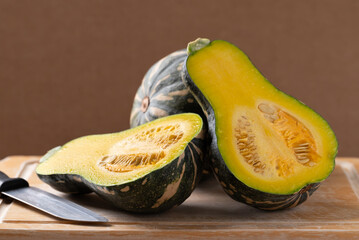 Half green butternut squash pumpkin on cutting wooden board