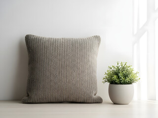 Knitted cushion and small potted plant on a table