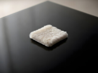 Soft fluffy textile swatch on reflective surface