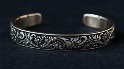 Elegant silver bracelet with floral pattern on dark background