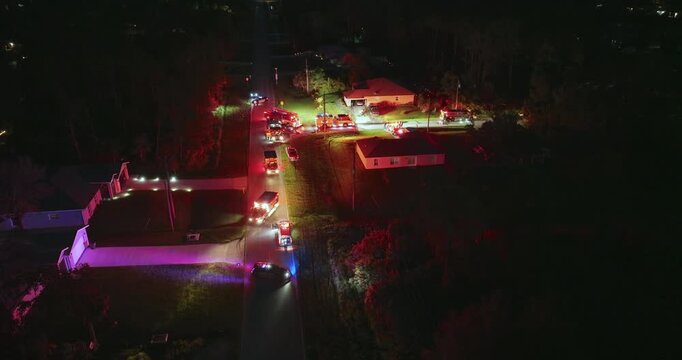 Emergency fire trucks at the scene. Investigation of carbon monoxide gas hazard at residential house in Florida, USA. Bright flashing lights at night.