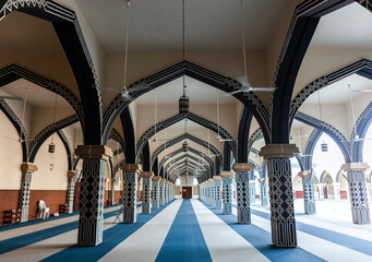 Intricate arches of Ruwi Mosque in Muscat, Oman. Islamic architecture with blue and white patterns. Traditional Arabian design in a serene interior.