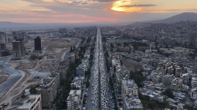 Aerial shot captures the Syrian capital at sunset, showing the city&rsquo;s skyline, streets, and urban areas as daylight fades over the capital.
