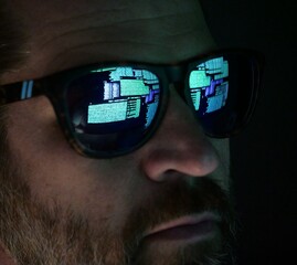 Man Hacking at Terminal Command Prompt Running Networks Scans and Packet Captures - Reflection in Glasses Black Hat Concept