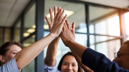 Team Harmony: A moment of unity and celebration as a group of individuals join hands in a high-five gesture, celebrating camaraderie and success in the workplace.