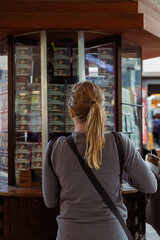 Woman stands in front of a lottery booth filled with tickets in Toluca, Mexico historic center