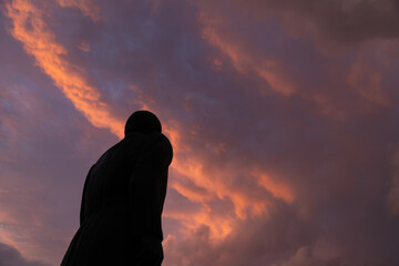 Silhouette of the historic Miguel Hidalgo statue against a dramatic orange and purple sky at sunset in Toluca, Mexico