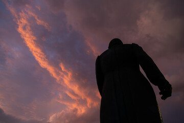 Silhouette of the historic Miguel Hidalgo statue against a dramatic orange and purple sky at sunset in Toluca, Mexico
