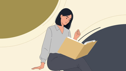 Young woman reading a large book while sitting in a minimalistic setting with abstract background