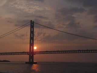 夕日に照らされた大きな吊り橋と海の風景