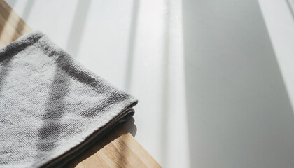 丁寧に畳まれたライトグレーのタオルと明るい余白