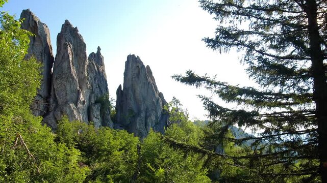 A picturesque summer landscape featuring the dramatic, high peaked sharp rock formations of Mount Perya within Taganai National Park, located in the Southern Urals region of Russia.