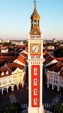 Aerial view of a historic clock tower and surrounding buildings with red roofs