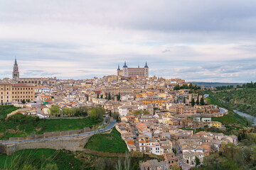 Scenic aerial view of Toledo Spain during spring twilight. The Rio Tajo river winds around the historic city center as a grand natural barrier.