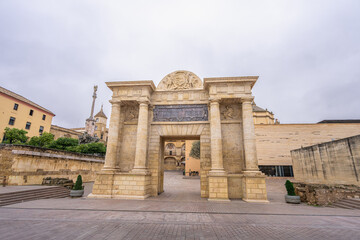 Renaissance triumphal arch gateway featuring Corinthian columns and heraldic crest in the historic old town of Cordoba, Andalusia, Spain.