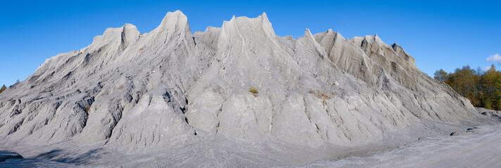 Panorama of bizarre mountains of marble chips on a sunny October day. Waste from the marble-lime plant in Ruskeala. Karelia, Russia