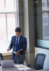 Fototapeta premium Businessman, documents and report with project at office for deal, proposal or feedback at insurance company. Person, paperwork and insight with folder, solution or job at risk assessment agency