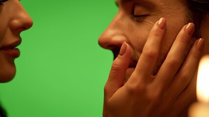 Warm, romantic close-up of a couple expressing affection, shot intimately against a bright green screen.