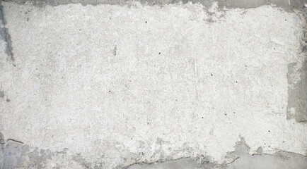 A grunge white concrete wall texture featuring a rough plaster surface with distressed edges revealing a gray underlying layer, ideal for abstract backgrounds.