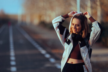 Woman in Sportswear Fixes Her Hair Before Walking Session. Stylish active girl ready for her...