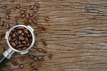 top view of coffee beans in a portafilter placed on an old wooden table, copy space