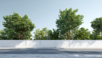 Long white wall along the side of a paved road with lush green trees behind it and a clear blue sky overhead