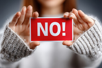 Woman holding red card with "no" message in focused gesture
