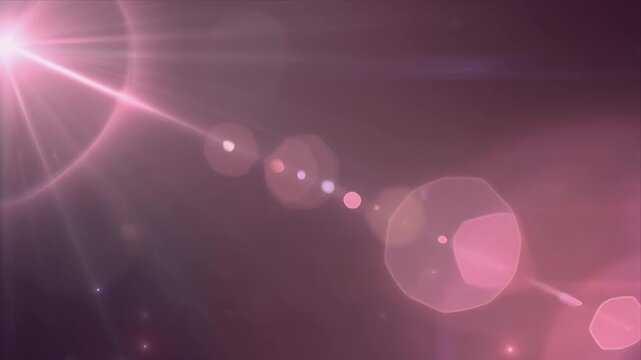 Ethereal pink light bursts through a dark abstract background creating beautiful shimmering optical lens flare effects