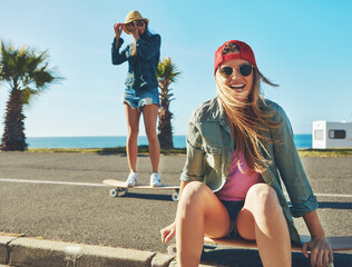 Happiness, skater or friends at promenade in summer, holiday training or outdoor in hobby. Smile, portrait or excited women at beach with board, sunglasses or vacation sport at seaside together
