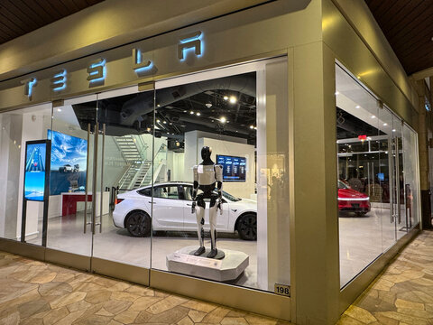 Tesla store with Tesla cars and humanoid robot in the showcase. AKA Optimus robot GEN 3. Waikiki, HI, USA - 25 December 2025