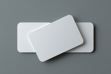 Two white rectangles with rounded corners on a gray surface, close-up