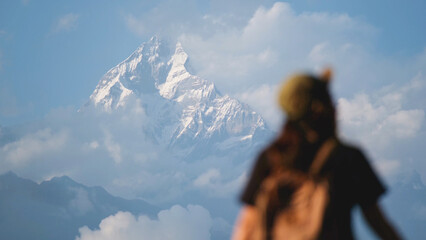Blurred rear view of a woman traveler looking at Machapuchare peak, Annapurna mountain range in Pokhara , Nepal