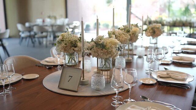 Decorated wedding table set with flowers candles plates and glassware