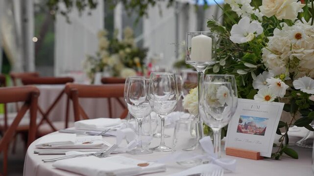 Charming wedding table setup featuring elegant floral centerpiece, glassware, and cutlery. Soft lighting and detailed decor create a romantic, intimate atmosphere. No people visible.