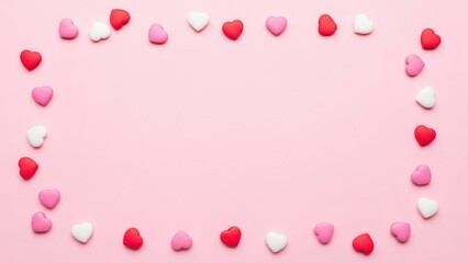 Scattered Pink and White Heart Shaped Candies on Soft Blush Background for Valentine Theme