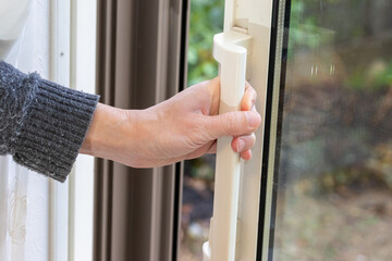 ガラス戸の取っ手を握って開け閉めする