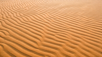 Top-down view of rippled desert sand concept. Waves of sand create a tranquil and mesmerizing desert scene.