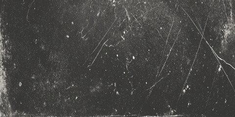 A grainy black and white texture displaying scratches and imperfections across a darkened surface resembling aged film