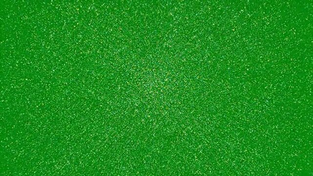 A green background with sparkling glitter particles in a video showcasing festive decorations . use as multipurpose tittle intro, gaming background. product mockup. motion graphics background