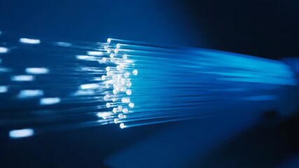 a bundle of fiber optic cables emitting bright blue light in a dark environment . use as multipurpose tittle intro, gaming background. product mockup. motion graphics background