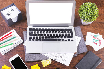 top view of messy workspace with laptop sketches and stationery