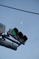 信号機と月。traffic light pole