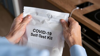 Person Holding COVID-19 Self-Test Kit Package