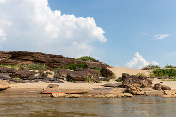 Rock formations standing in clear blue sea water along a peaceful coastal landscape under a bright sky